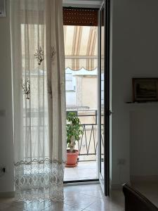 an open glass door to a balcony with a plant at La casa di Nonna Celeste in Brindisi