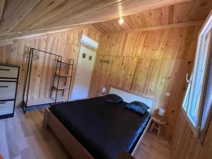 a bedroom with a bed in a wooden room at Chalet Nala in La Bresse +1 photo