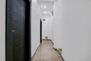 um corredor de uma casa com uma parede branca e duas plantas em Sunshine Residency em Rāmnagar