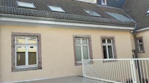 een huis met 3 ramen en een wit balkon bij Stadthaus Room 2 mit Hochbett for 3 Persons or Eltern mit 2 Kindern in Mannheim