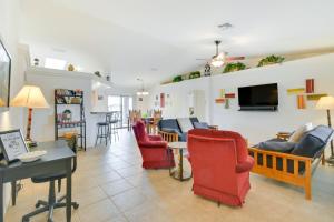 a living room with red chairs and a tv at Patio, Views and Boat Parking Lake Havasu Home! in Lake Havasu City