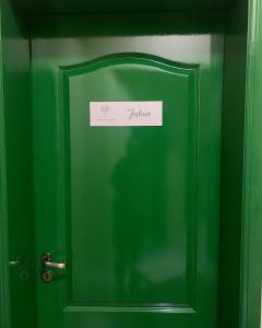 a green door with a sign on it at Joshua Tree Hostel - Curitiba in Curitiba