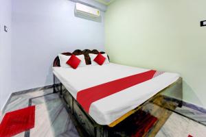 a bedroom with a bed with red pillows on it at Hotel O Laxmi Marriage Hall Restaurant And Guest House in Islāmpur