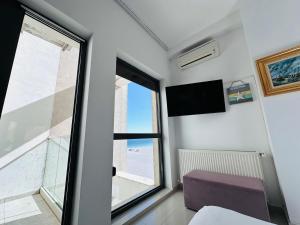 a room with a large window and a tv at Riviera Studios in Mamaia