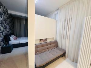een slaapkamer met een bank en een bed in een kamer bij Riviera Studios in Mamaia