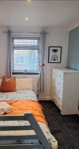 a bedroom with a bed and a dresser and a window at LUTON AIRPORT PROFESSIONALS CONTRACTORS Beds Uni students Welcome in Luton