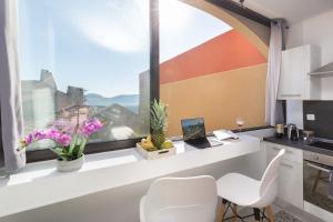 een keuken met een raam met een bureau en stoelen bij Sweet Calanque - Host Provence in Cassis