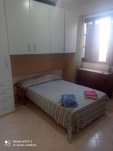 クアルトゥ・サンテーレナにあるCasa Vacanze Torre Foxiの小さなベッドルーム(ベッド1台、白いキャビネット付)