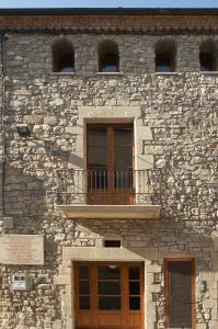a stone building with a balcony on top of it at Ca naleix verdu in Verdú