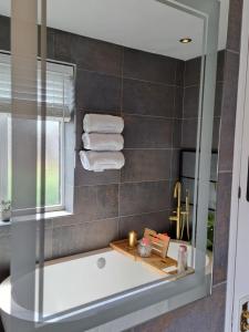 a bathroom with a tub and a window and towels at LUTON AIRPORT PROFESSIONALS CONTRACTORS Beds Uni students Welcome in Luton