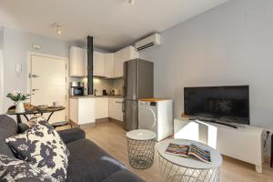 a living room with a couch and a kitchen at Charming 2 Bedroom Apartment at Rodrigo de Triana By Oui Seville in Seville