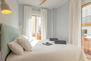 a bedroom with a large white bed with a window at Charming 2 Bedroom Apartment at Rodrigo de Triana By Oui Seville in Seville