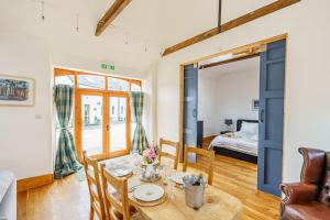 a living room with a table and a bedroom at The Haybarn in Dundrennan