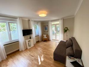 uma sala de estar com um sofá e uma televisão em Ruhiges WG-Appartment in Einfamilienhaus em Glashütten