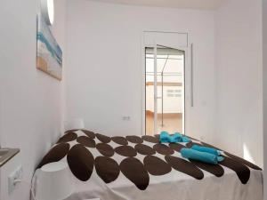 biała sypialnia z czarno-białym kocem na łóżku w obiekcie Apartamento a 50m de la playa w mieście Platja  d'Aro