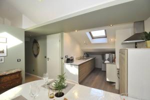 een keuken met een tafel en een witte koelkast bij LE CHALEUREUX 60M2 à 200M Place Stanislas in Nancy