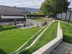 a backyard with grass and a retaining wall at Cozy holiday home in Bavaria in a charming area in Beilngries