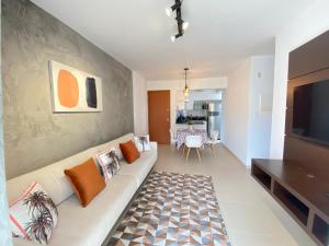 a living room with a couch and a television at Aconchegante apto 2/4 Setor Bueno 1307 in Goiânia