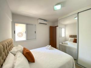 a bedroom with two beds and a mirror at Aconchegante apto 2/4 Setor Bueno 1307 in Goiânia