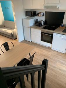 a kitchen with a table and a kitchen with a stove at Côté Source in Pornic