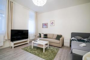 een woonkamer met een bank en een tv bij Lucy's Apartments 2 in Olomouc
