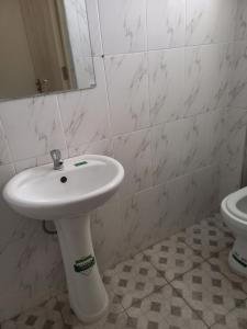 een badkamer met een witte wastafel en een toilet bij Specious 1bedroom near JKIA in Nairobi
