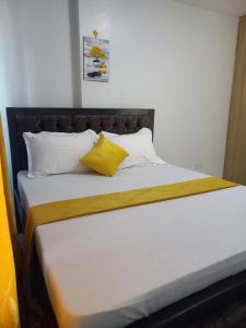 een bed met twee gele kussens erop bij Specious 1bedroom near JKIA in Nairobi