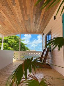 een veranda met een houten plafond en 2 stoelen bij La Casa de Paz Hotel in San Pedro