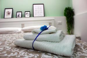 een stapel handdoeken bovenop een bed bij Lalla Home in Bari