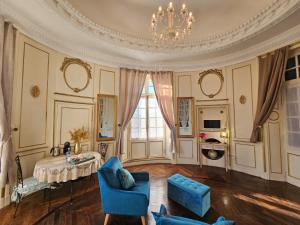 Vicq-dʼAuribat的住宿－Château Arche d'Aure，客厅配有桌椅和吊灯。