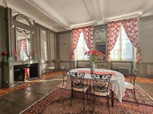 uma sala de jantar com uma mesa com um vaso de flores em Château Arche d'Aure em Vicq-dʼAuribat