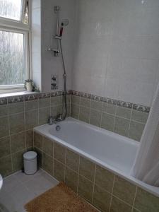 a bathroom with a bath tub and a window at 2 Bed Mill Hill Flat in Mill Hill