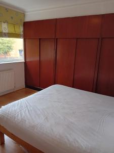 a bedroom with a large bed with a wooden headboard at 2 Bed Mill Hill Flat in Mill Hill