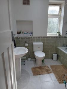 a bathroom with a toilet and a sink and a tub at 2 Bed Mill Hill Flat in Mill Hill