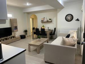 een woonkamer met een witte bank en een tafel bij Triptolemus Stay Inn in Elefsina