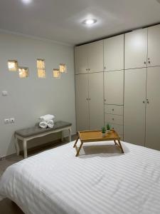 a bedroom with a bed with a table and cabinets at Triptolemus Stay Inn in Eleusis