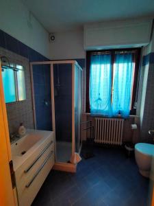 a bathroom with a shower and a tub and a sink at La Magnolia - Fano in Fano