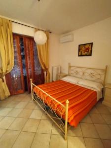a bedroom with a bed with an orange blanket at La Magnolia - Fano in Fano