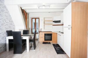 a kitchen with a table and chairs and a kitchen with white cabinets at Maison hyper centre Romilly-sur-Seine in Romilly-sur-Seine