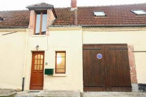 uma casa branca com uma porta castanha em Maison hyper centre Romilly-sur-Seine em Romilly-sur-Seine
