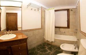 a bathroom with a sink and a toilet and a tub at Nepenpiren in San Martín de los Andes