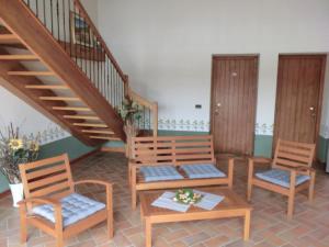科尔蒙斯Agriturismo Domus Rustica的一间设有三把椅子的房间和一个楼梯
