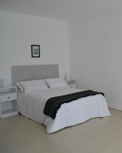 - une chambre blanche avec un lit et un mur blanc dans l'établissement Departamento nuevo en Puerto Madero - Torre 11 de Madero Harbour -, à Buenos Aires