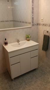 y baño con lavabo blanco y espejo. en APARTAMENTO PLAYA AZUL en Rincón de la Victoria