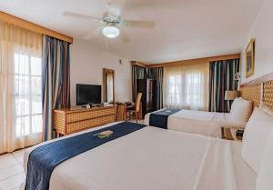 a hotel room with two beds and a flat screen tv at Caribbean Palm Village Resort in Palm-Eagle Beach +6 photos