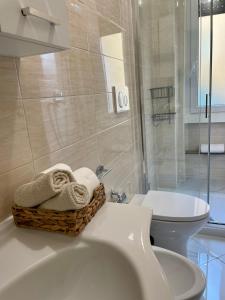 łazienka z toaletą i koszem ręczników w obiekcie Guest House (15 min metro dal Duomo) w Mediolanie