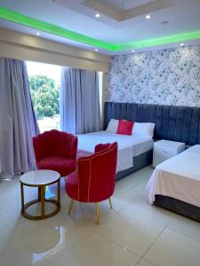 a hotel room with two beds and a table and chairs at Hotel AquaRoma in Higuey