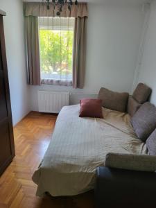 - un lit dans une chambre avec un canapé et une fenêtre dans l'établissement Káli medence kapuja 1, à Zánka