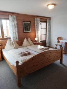 a large wooden bed in a room with windows at Vorderkasbichlhof in Saalfelden am Steinernen Meer