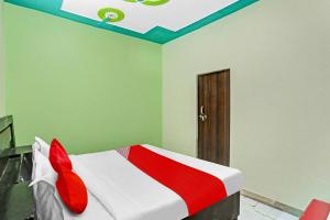 - une chambre dotée d'un lit avec des draps rouges et blancs dans l'établissement OYO Flagship Green Well Hotel & Restaurant, à Rewāri